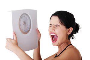 Woman Holding Scale because of healthy foods that can make you fat - Surprising Foods